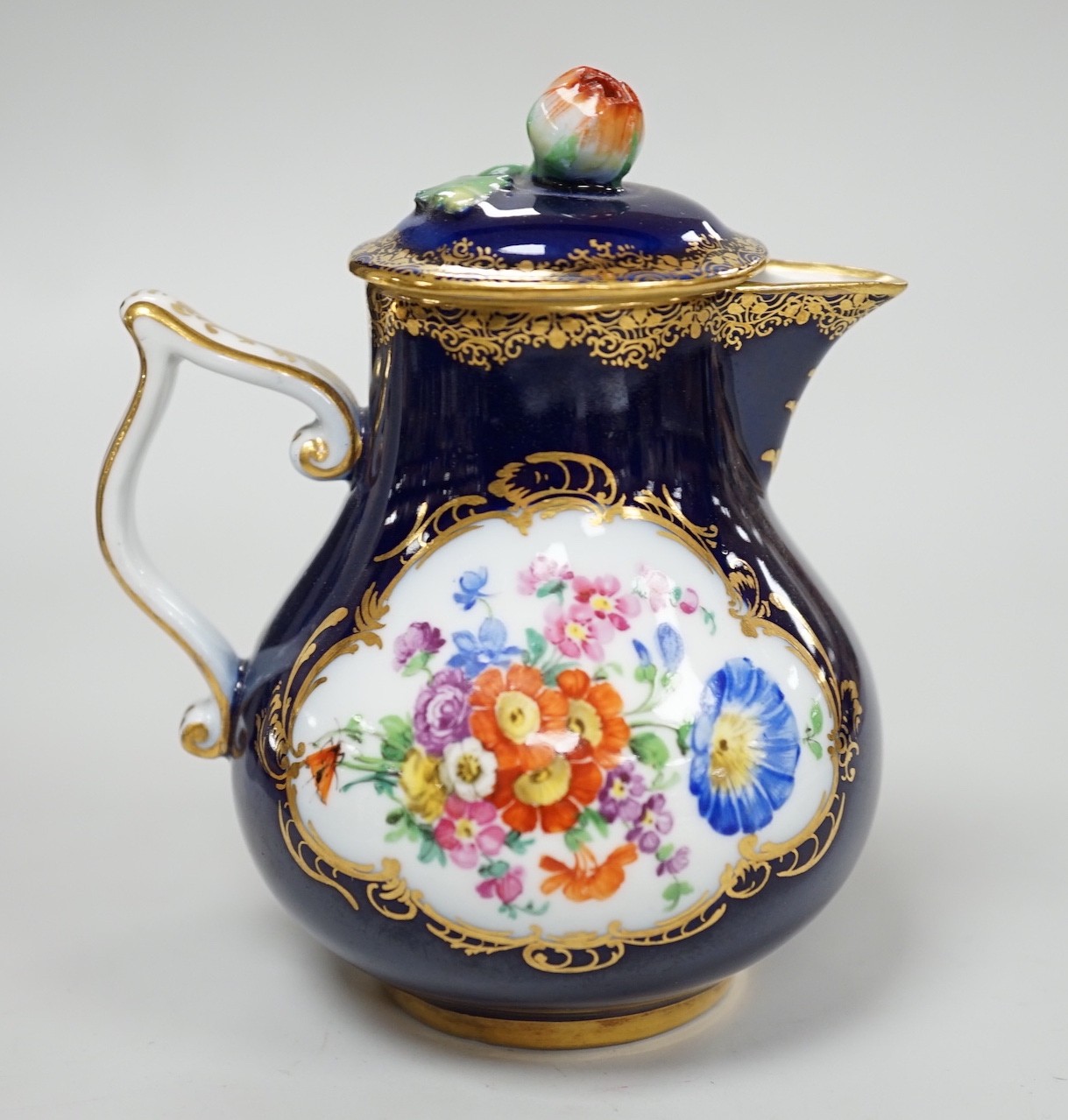 A small 19th century Meissen cobalt blue ground jug and cover, 9.5cm tall